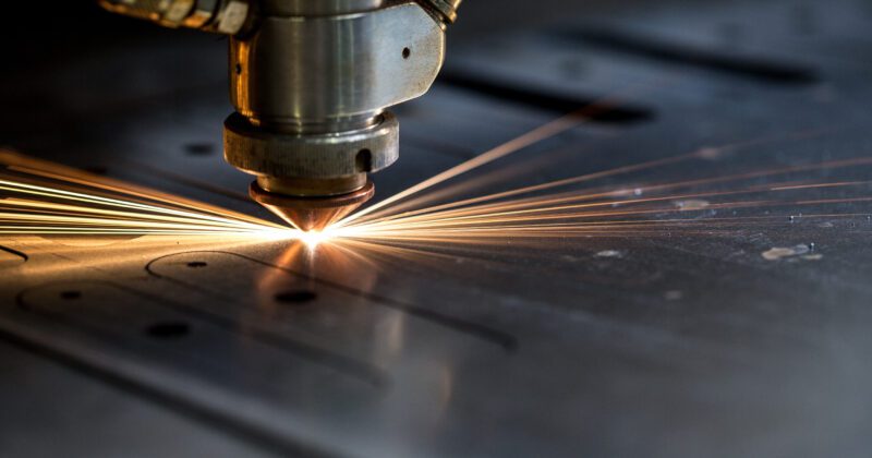 Cutting of metal. Sparks fly from laser, close-up